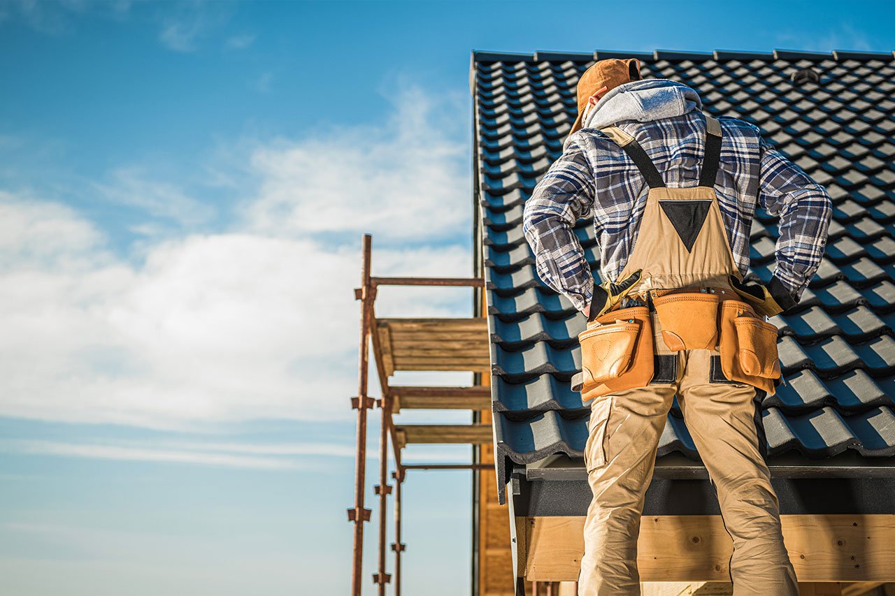 Roofer standing next to a roof